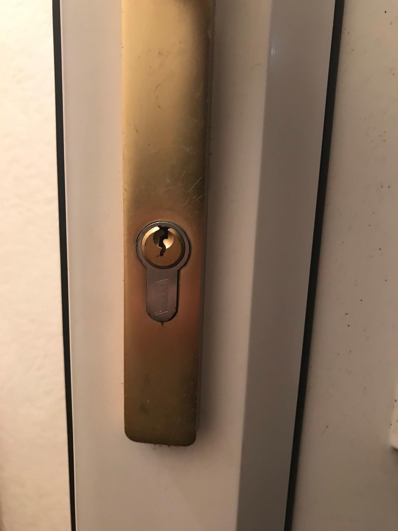 A euro cylinder lock in a gold door handle plate